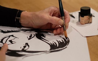 Hand die een portret tekent. Op zaterdag 9 januari 2016 geeft Annemiek Tijsseling de workshop "Portret in inkt" de opbrengst komt ten goede aan de Roparun.